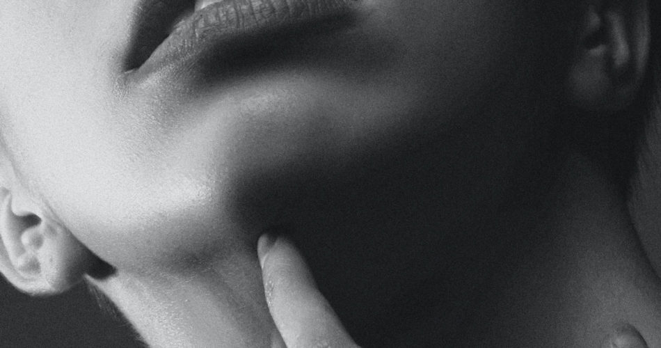 black and white image, close up of woman's mouth, chin and neck showing sensitive skin